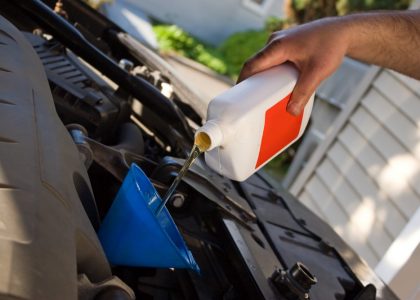 mechanic putting fluid into car